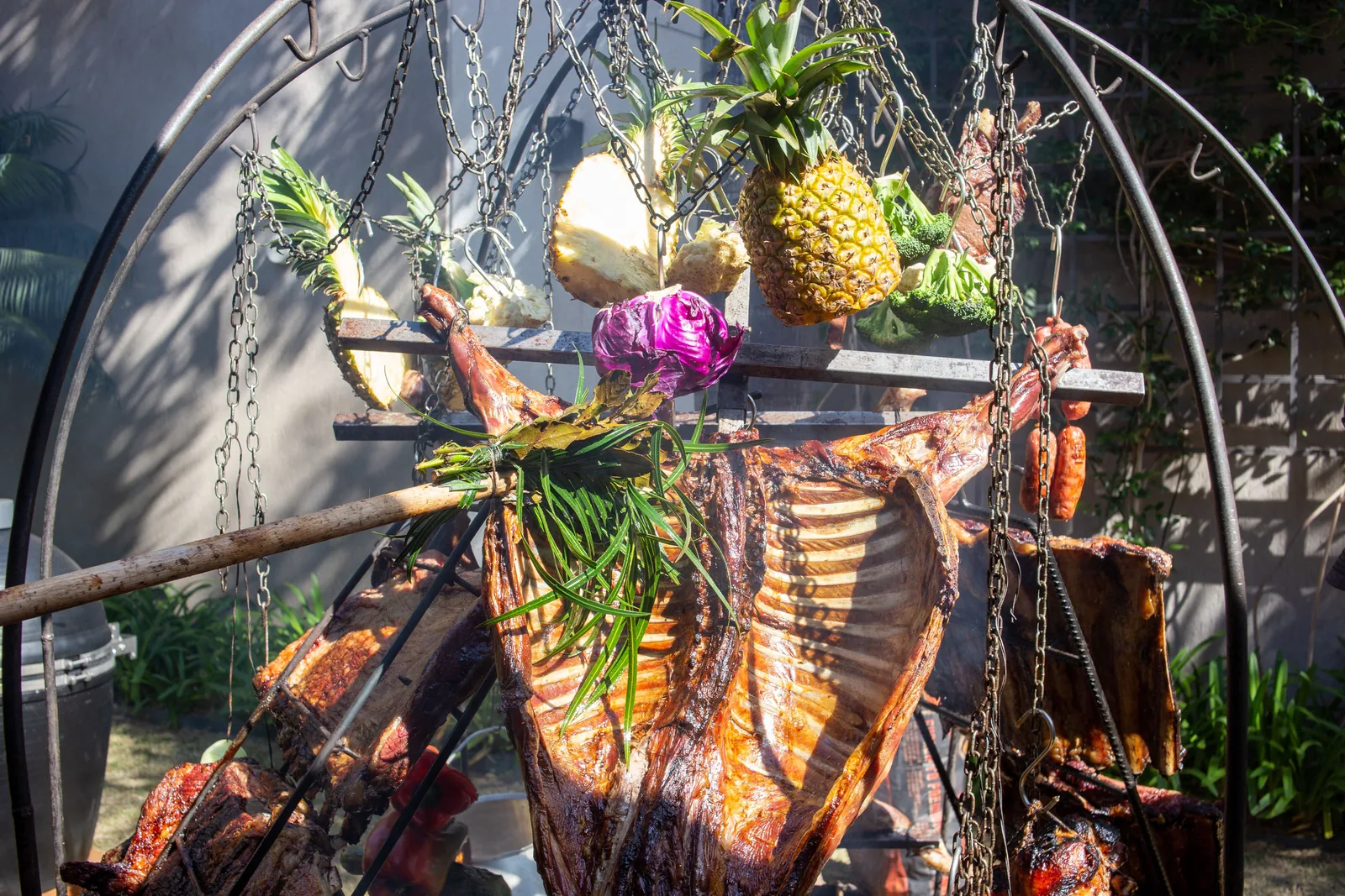 Marinated pork stacked on a vertical spit with pineapple on top