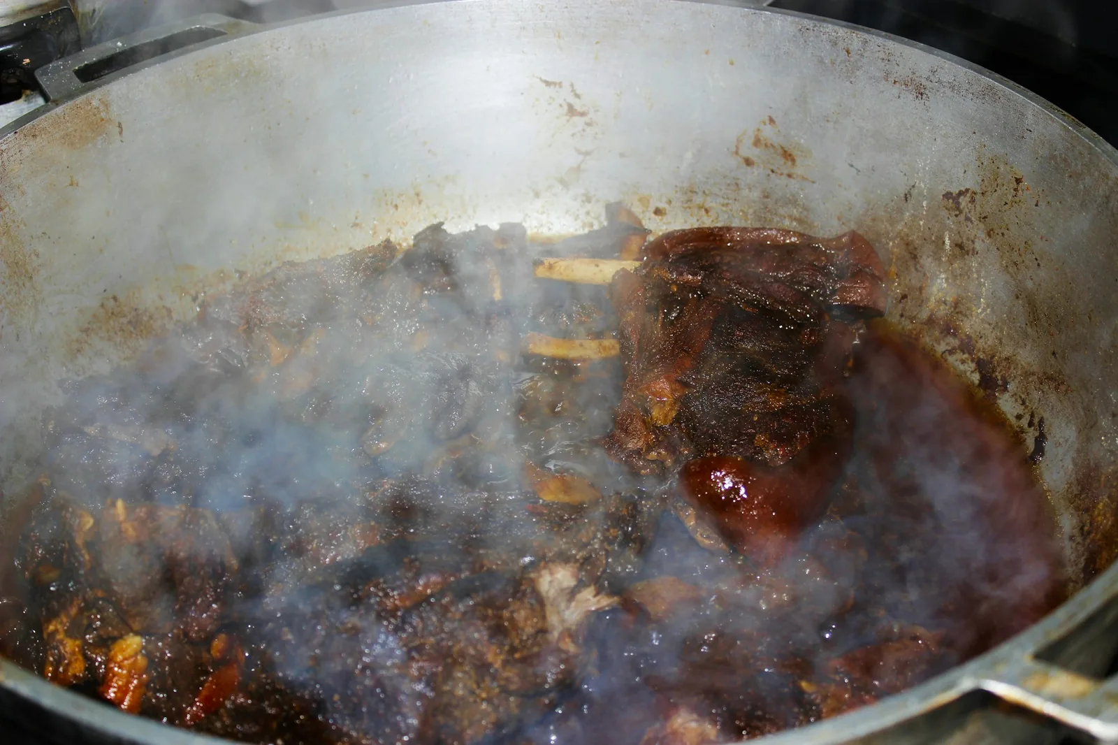 Meat simmering in a dark chile broth