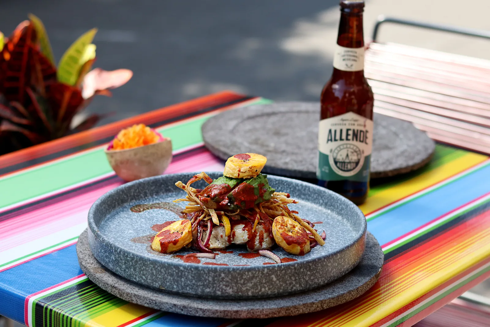 A beer served alongside a plate of food