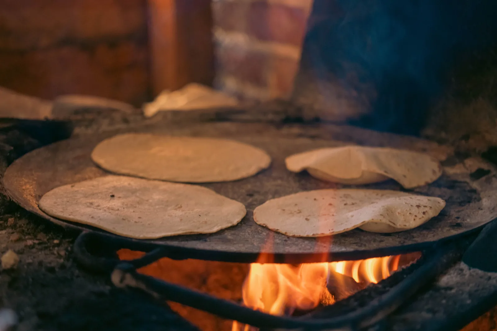 Corn tortillas warming on a hot griddle