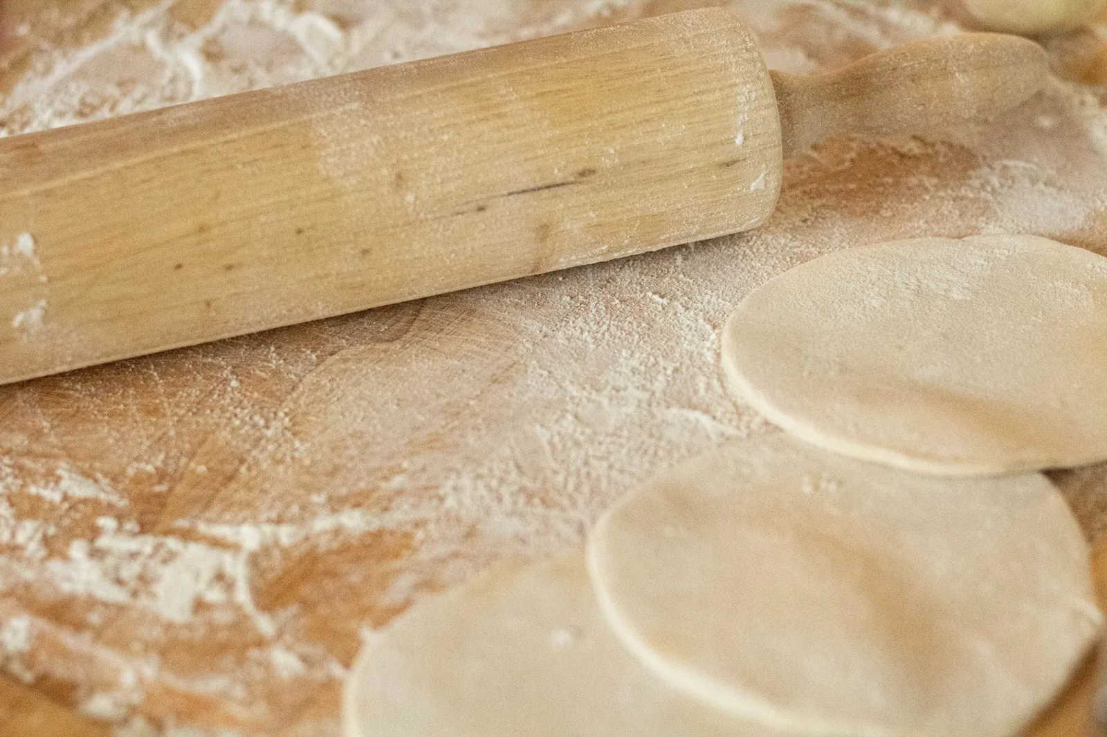 Flour tortilla dough being rolled out by hand