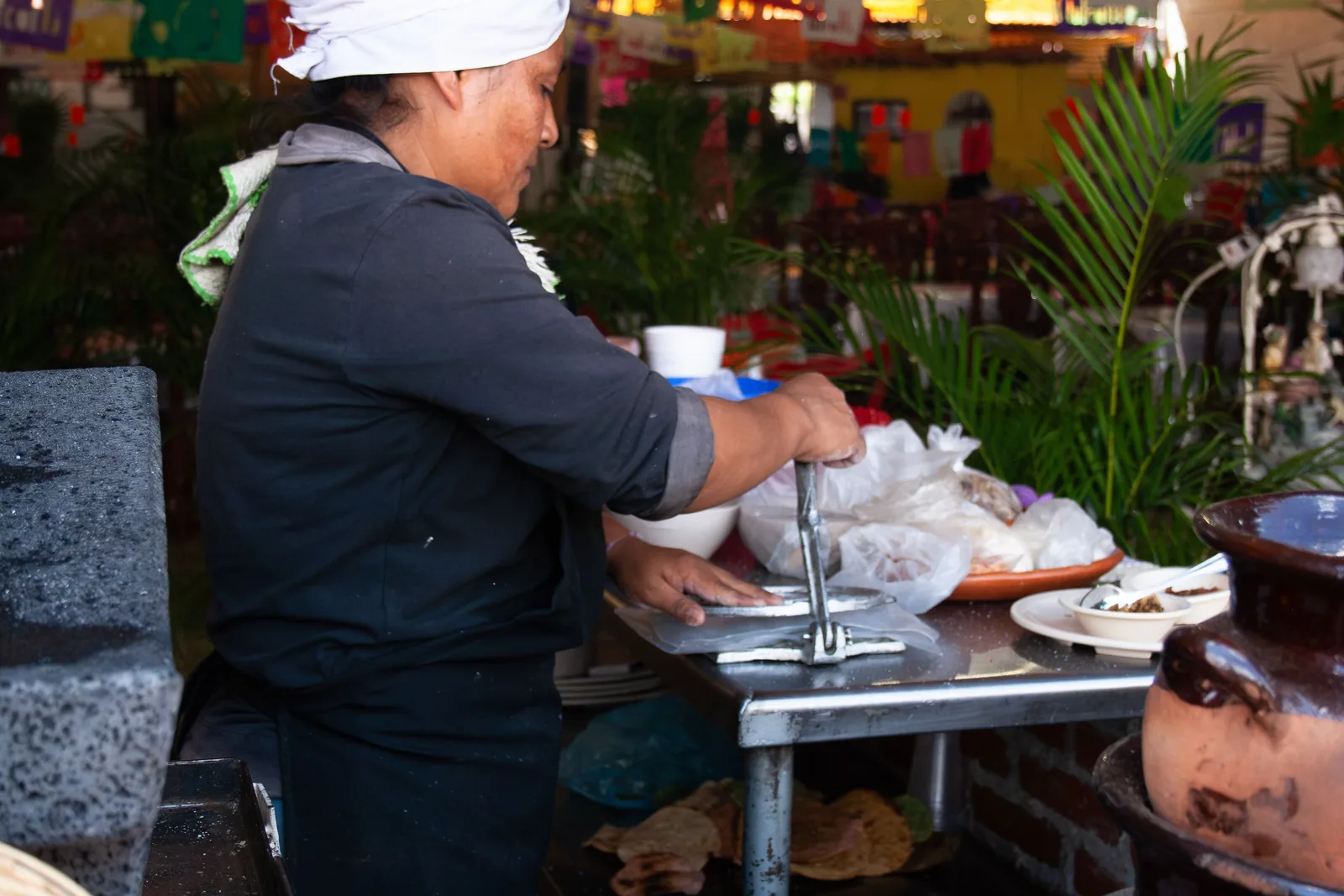 Fresh masa being pressed into corn tortillas