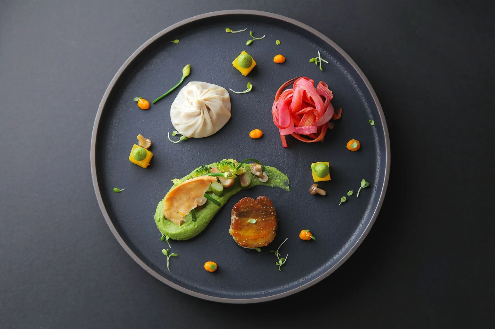 A fried dish finished with guacamole, cream and cheese