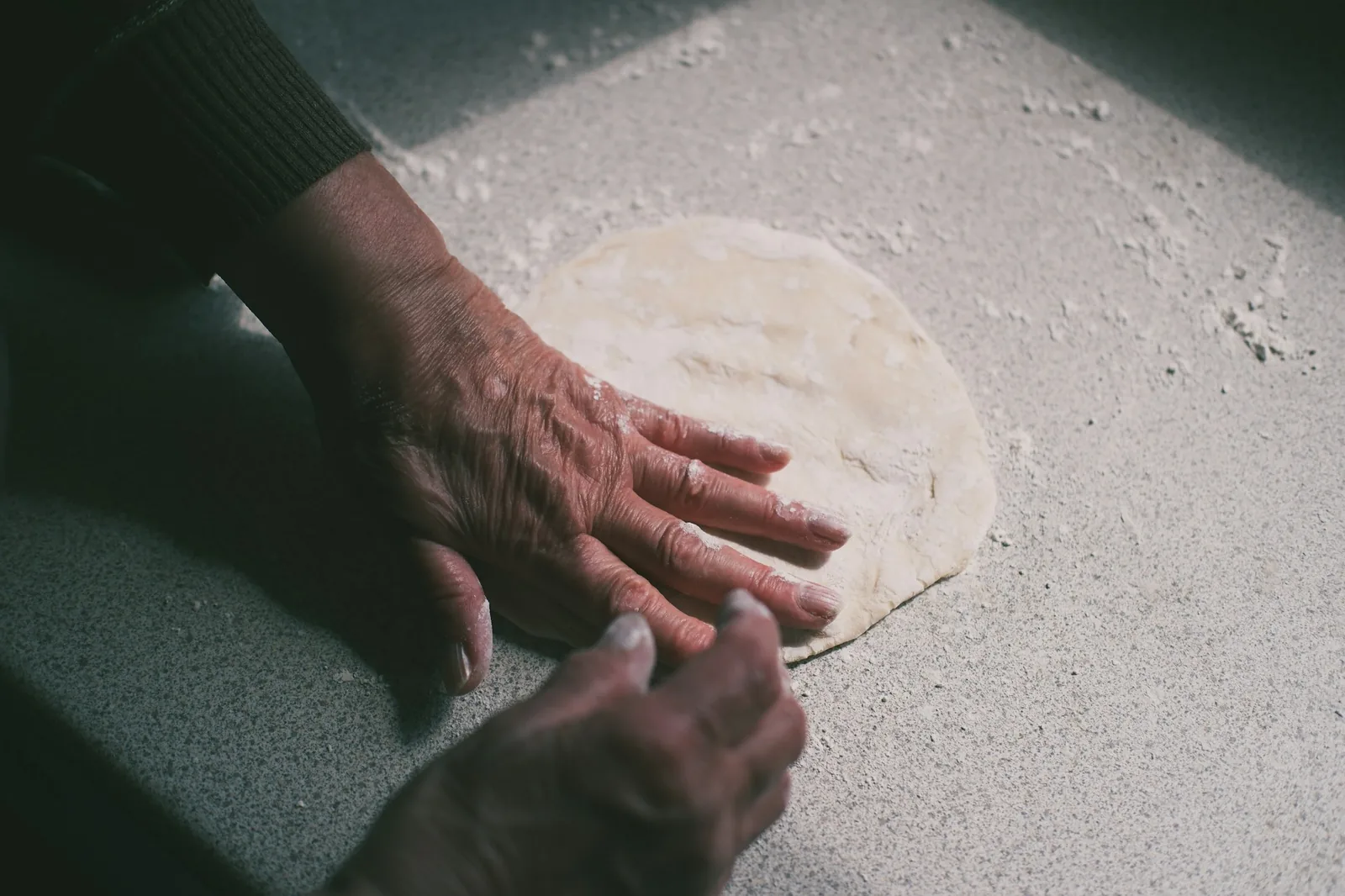A large flour tortilla being folded and sealed