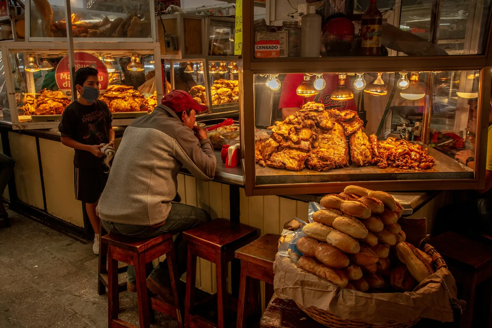 A market vendor serving cooked meat by weight