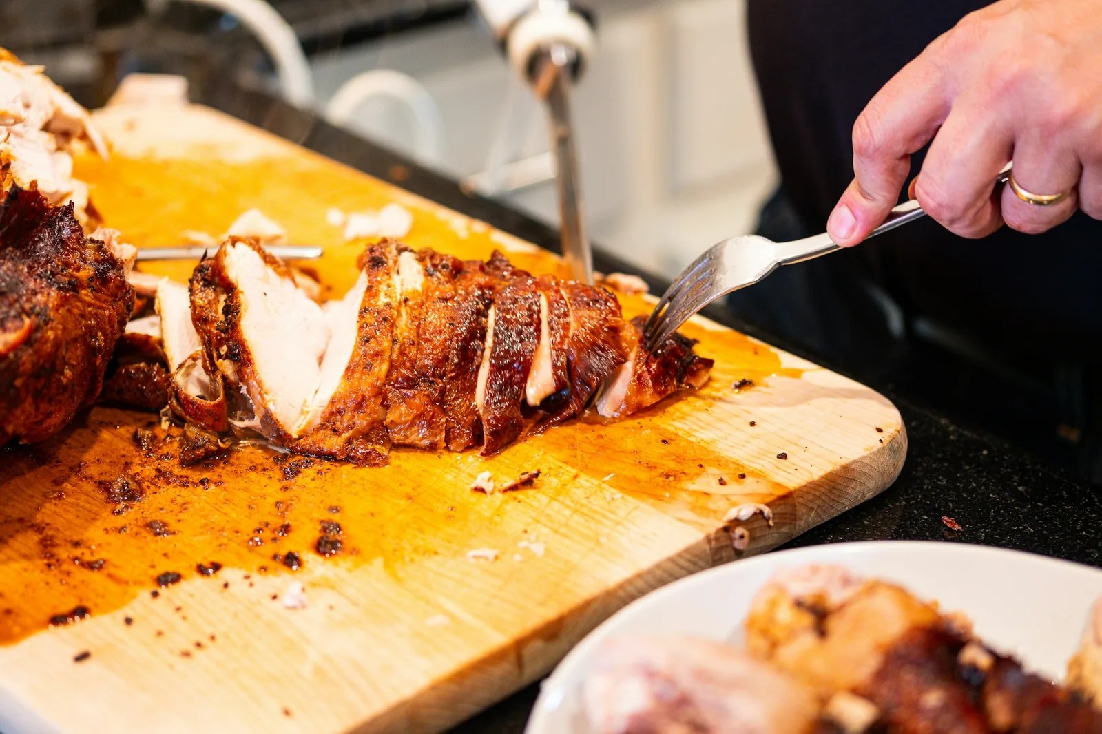 Cooked pork being pulled apart with forks