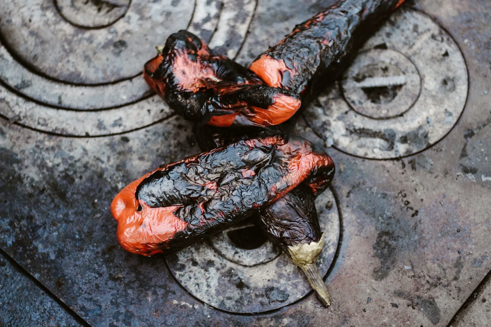 Peppers charring over a flame so the skin can be peeled