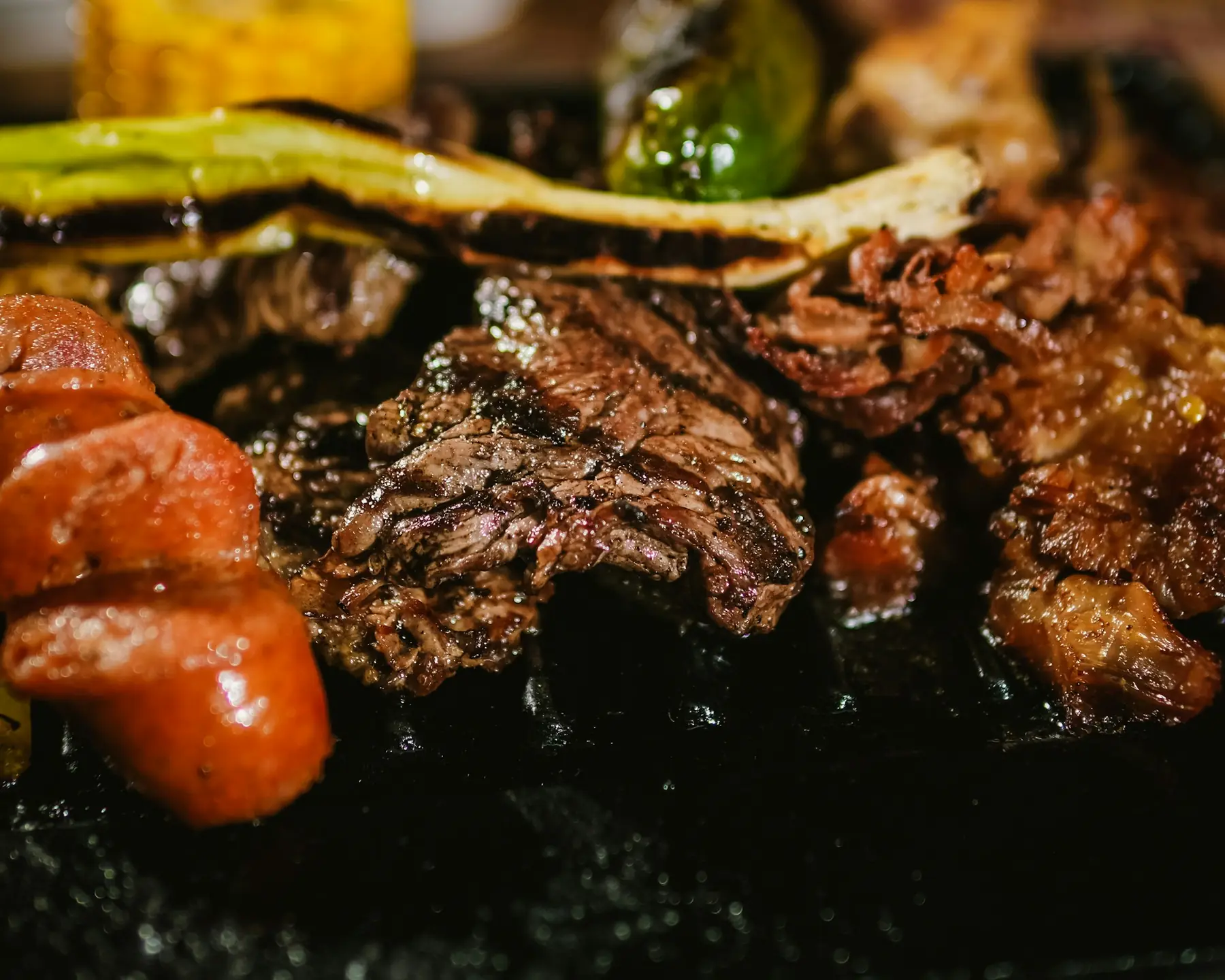 Marinated beef and grilled spring onions searing on a hot grill
