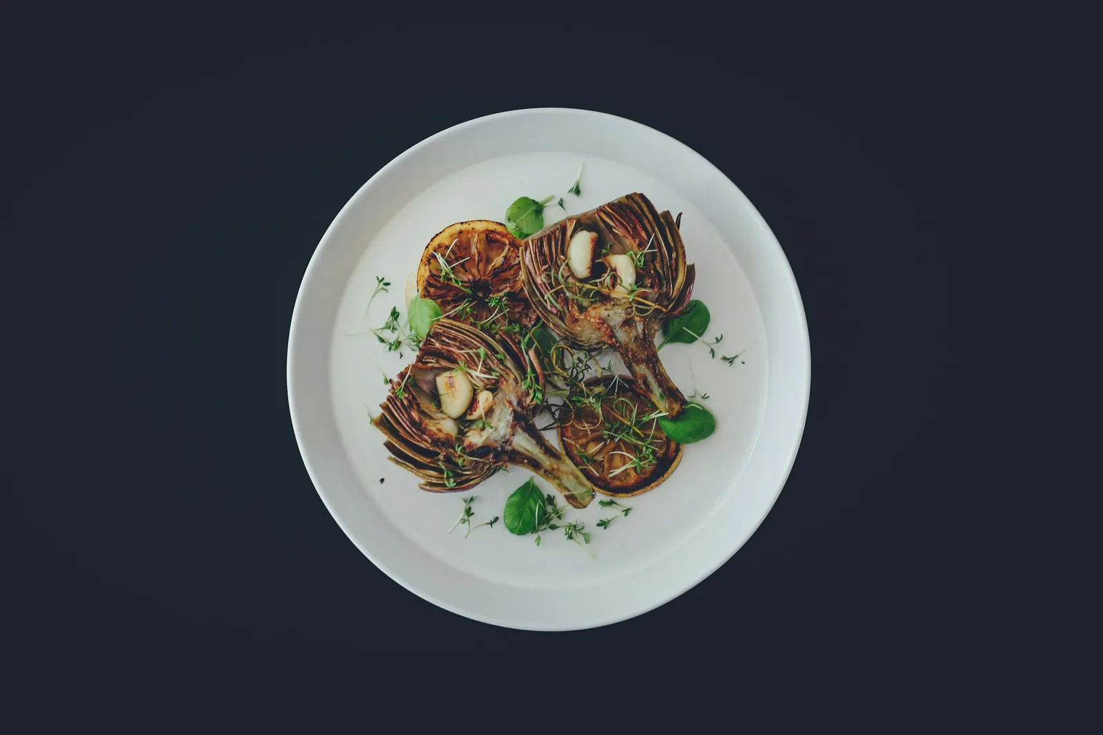 A plated dish finished with cream, cheese and raw onion