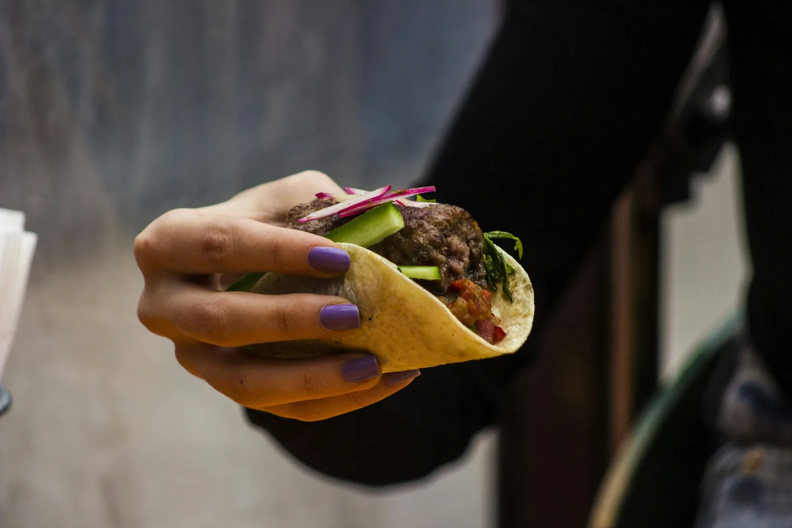A taco held folded in one hand