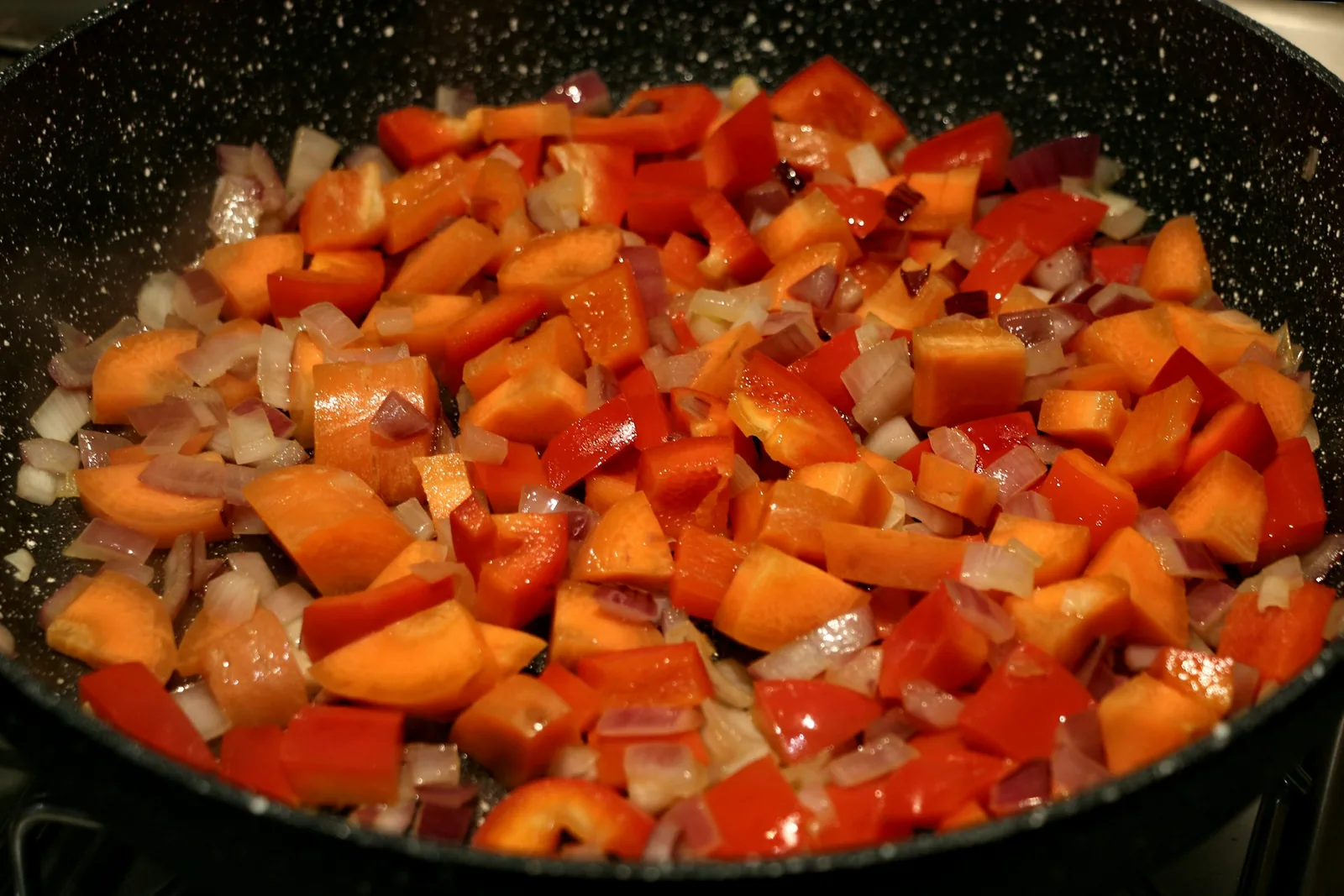 Sliced peppers and onions cooking down