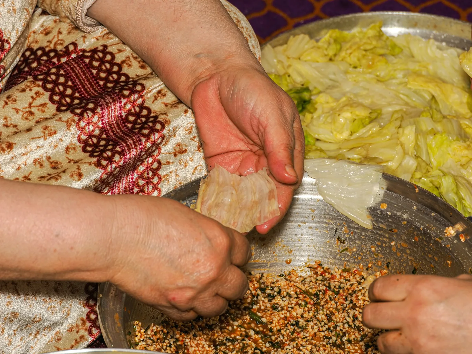 A filled tortilla being rolled tightly