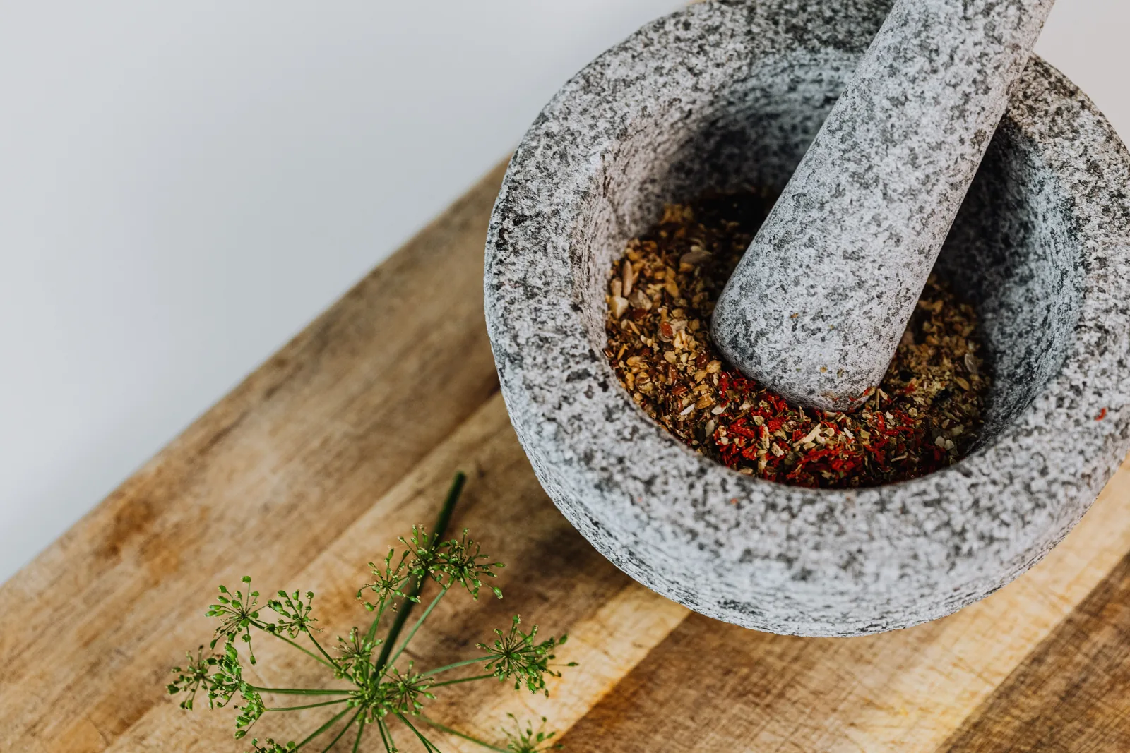 Dried herbs being crushed in a mortar