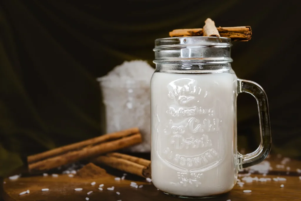 A tall glass of horchata served over ice with cinnamon