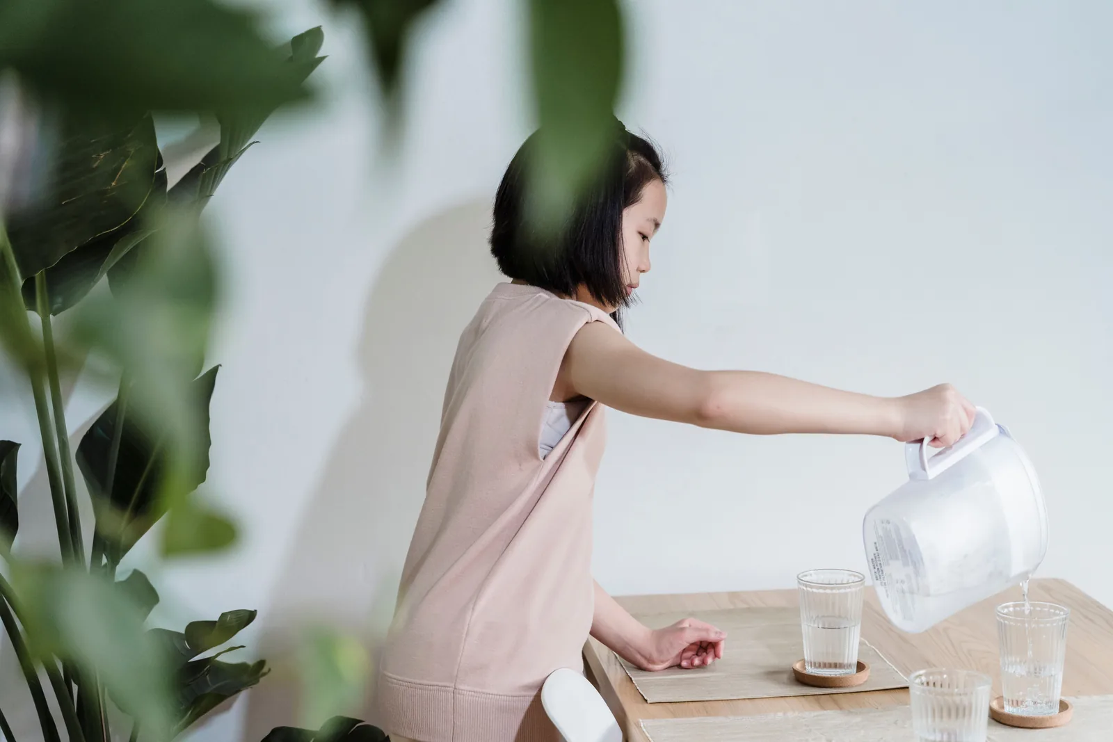 A pale, milky drink being poured from a pitcher