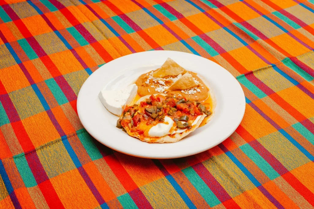 Fried eggs on tortillas covered in warm salsa