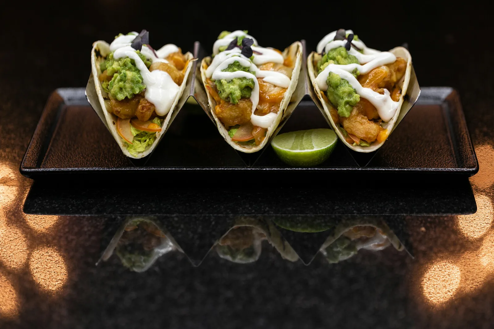 A simple plate of three tacos with onion and cilantro