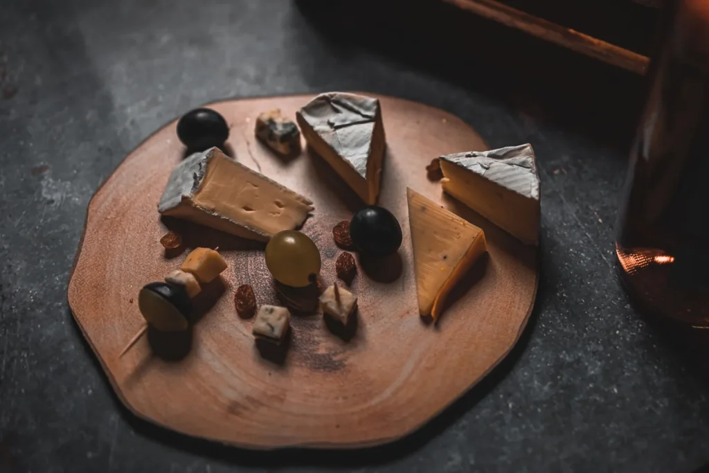 An assortment of white cheeses on a board