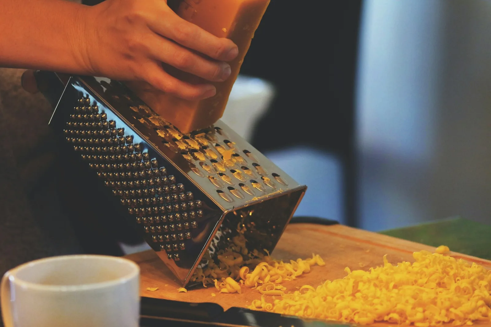 A hard aged cheese being grated