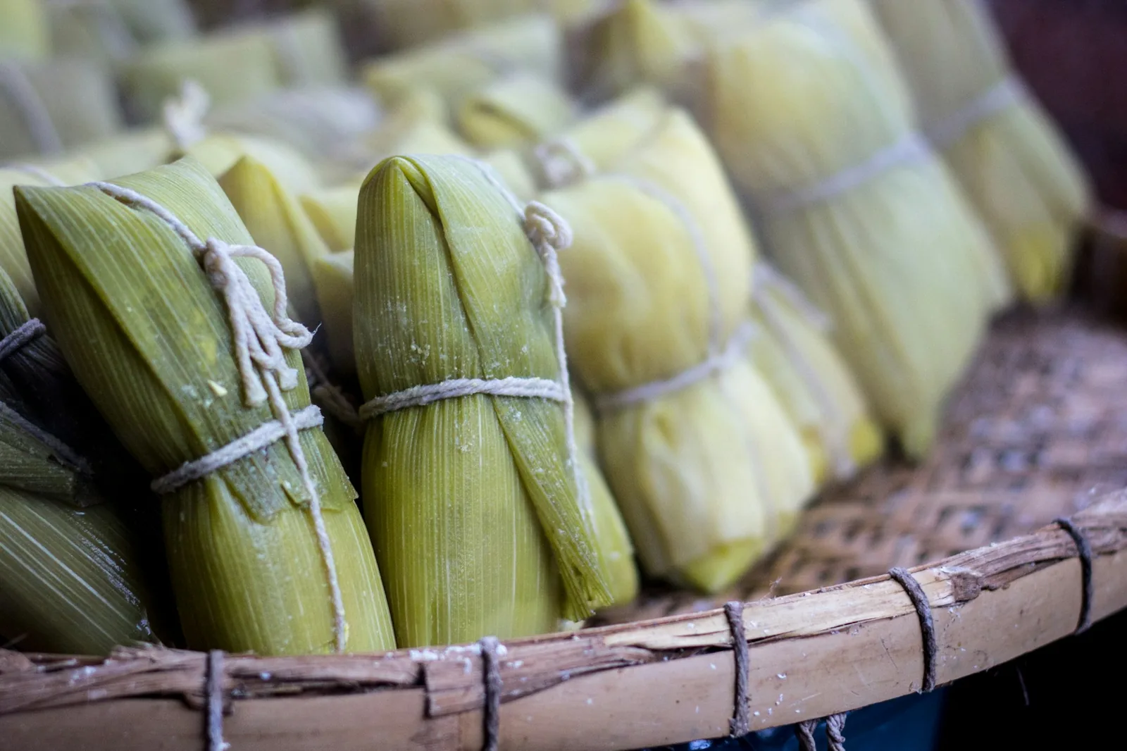 A triangular masa parcel wrapped in corn leaf