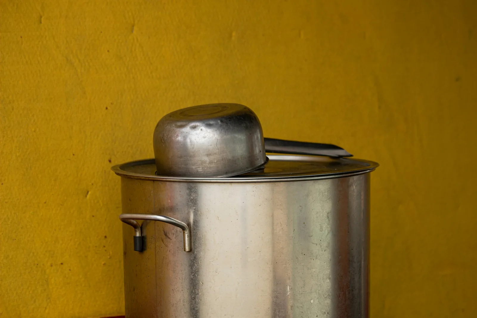 A deep red broth simmering in a large pot
