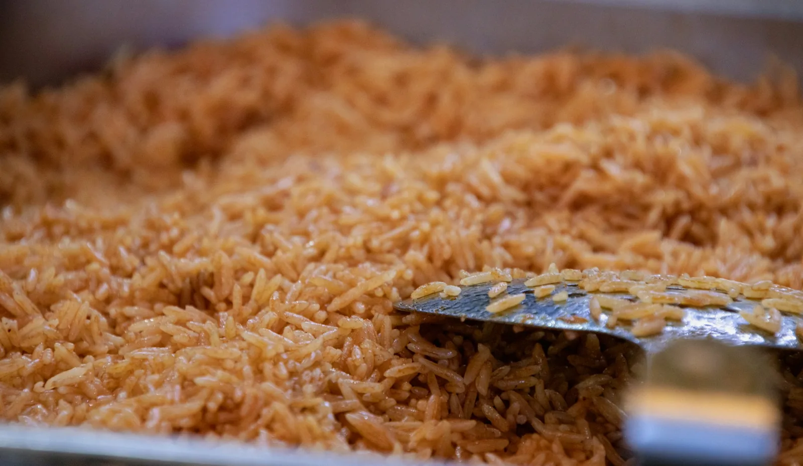 Cooked rice being fluffed with a fork