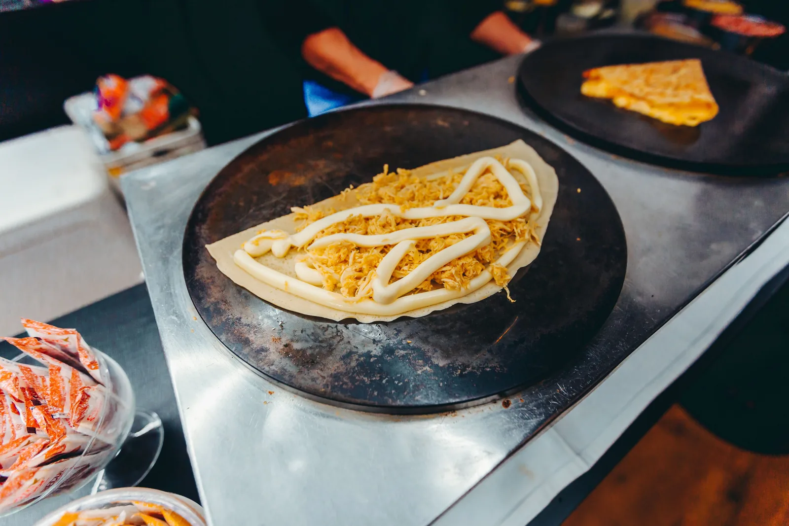 A folded quesadilla cooking on a street griddle