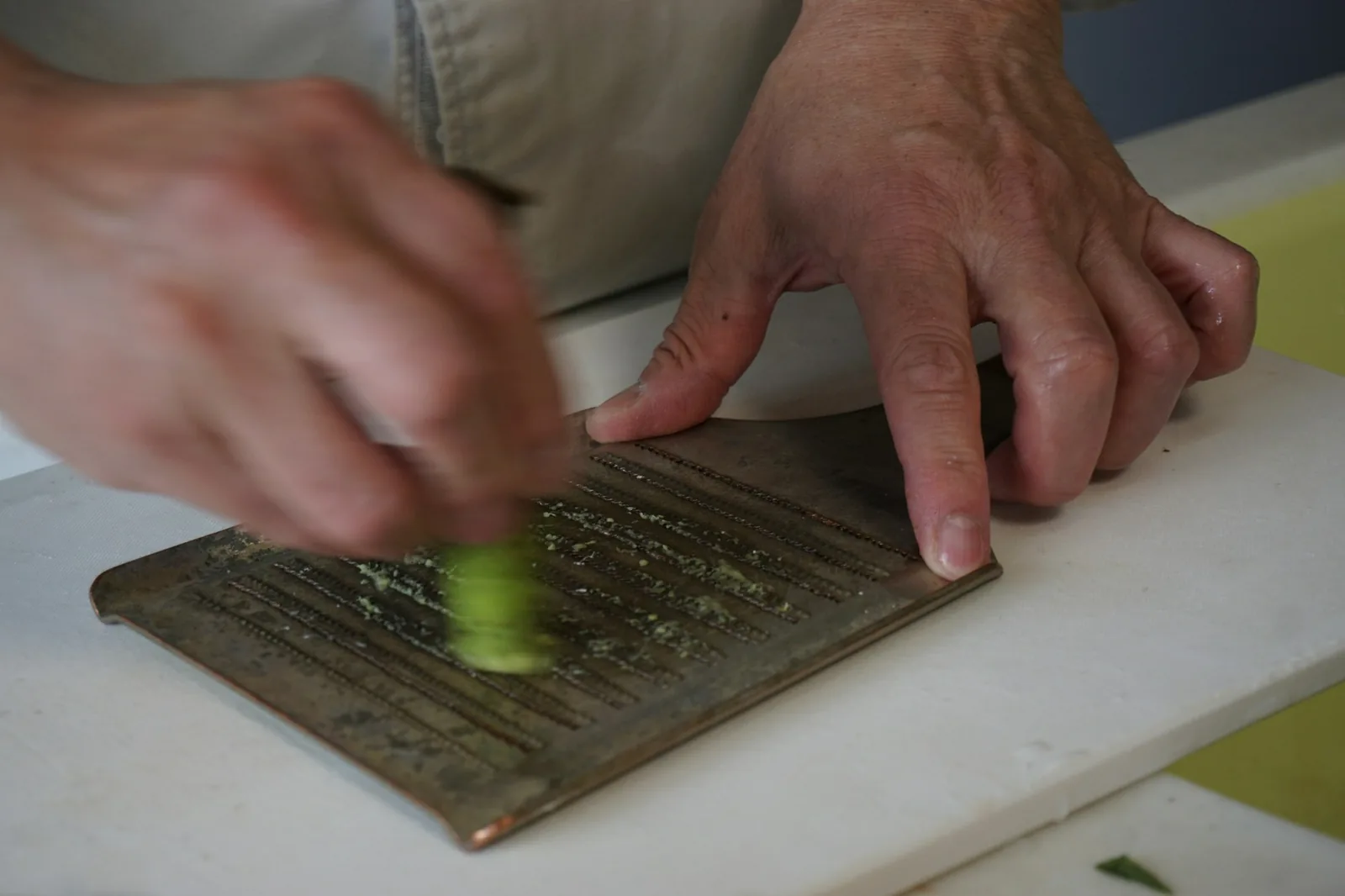 A cactus pad being trimmed with a knife