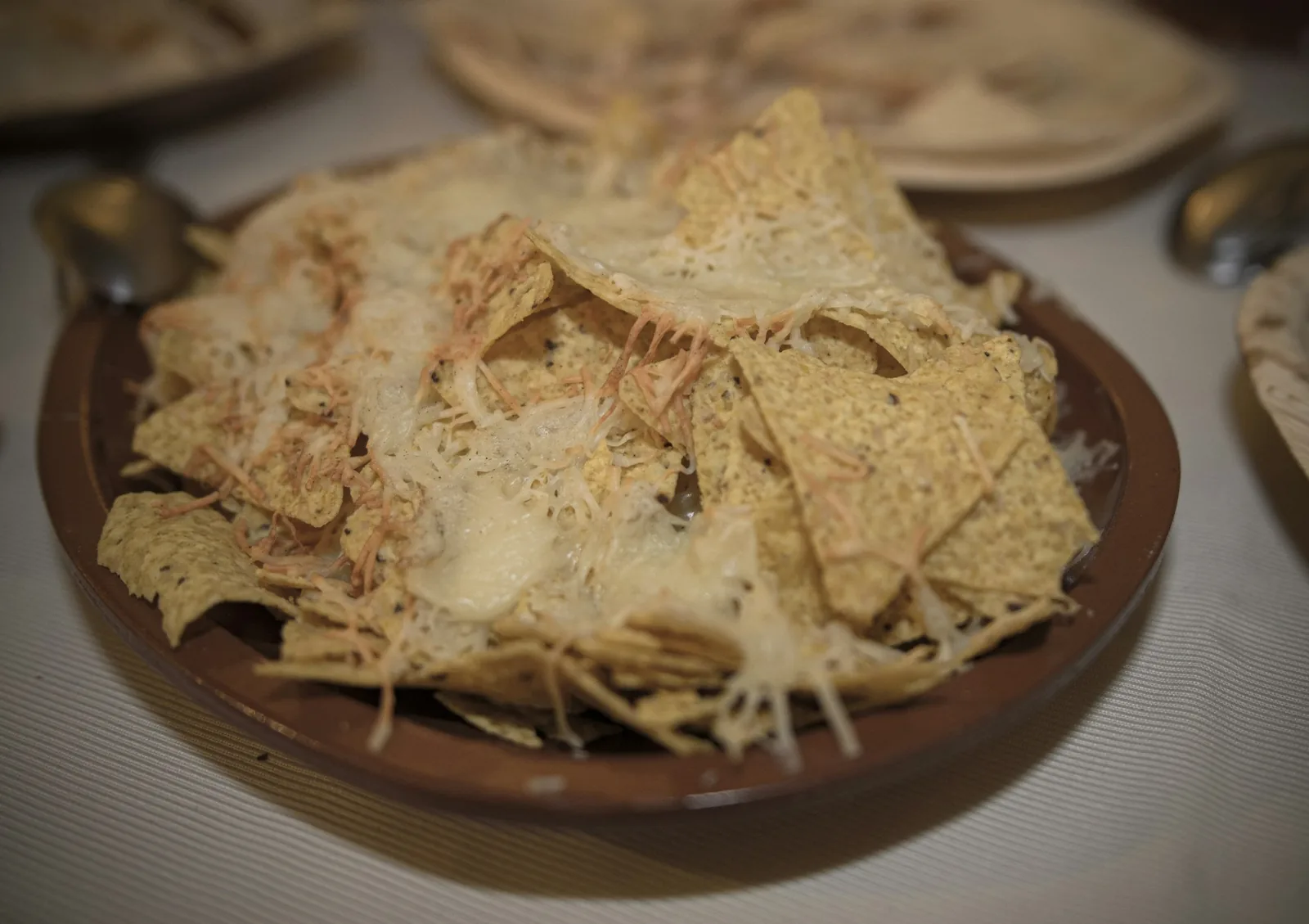 A large, crisp tortilla spread with beans and cheese