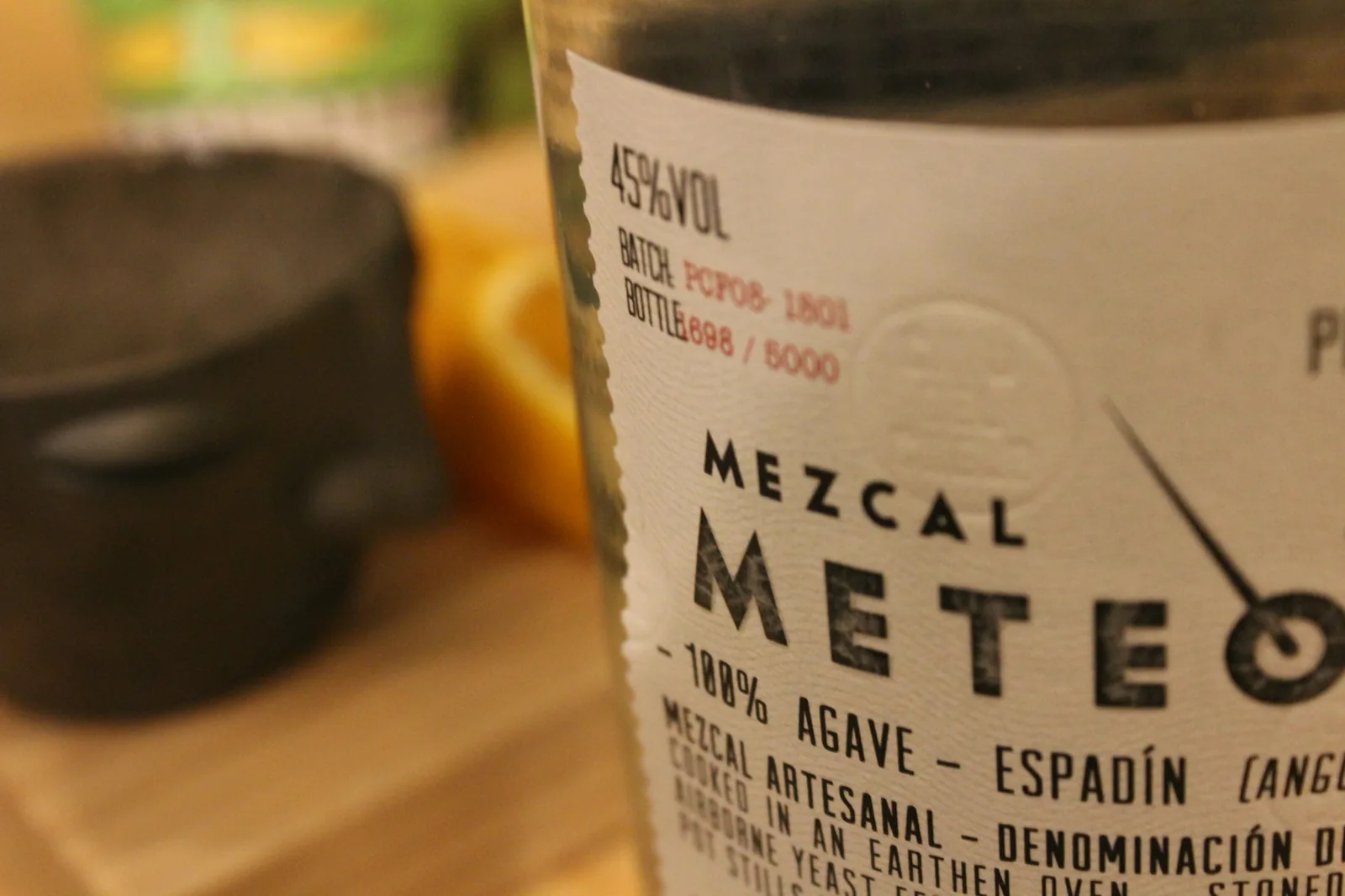 A glass of agave spirit served with orange