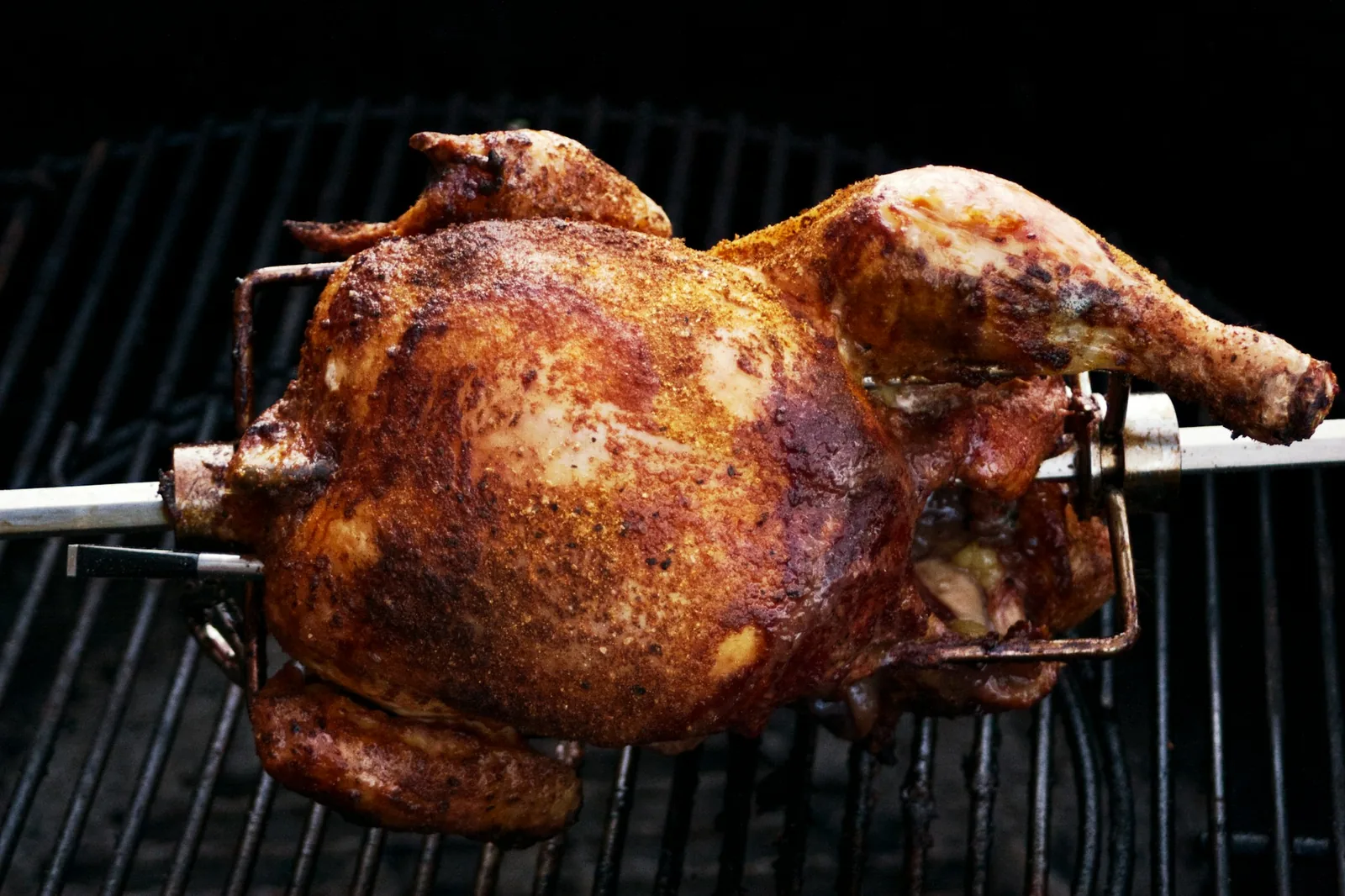 A butterflied chicken flattened on the grill