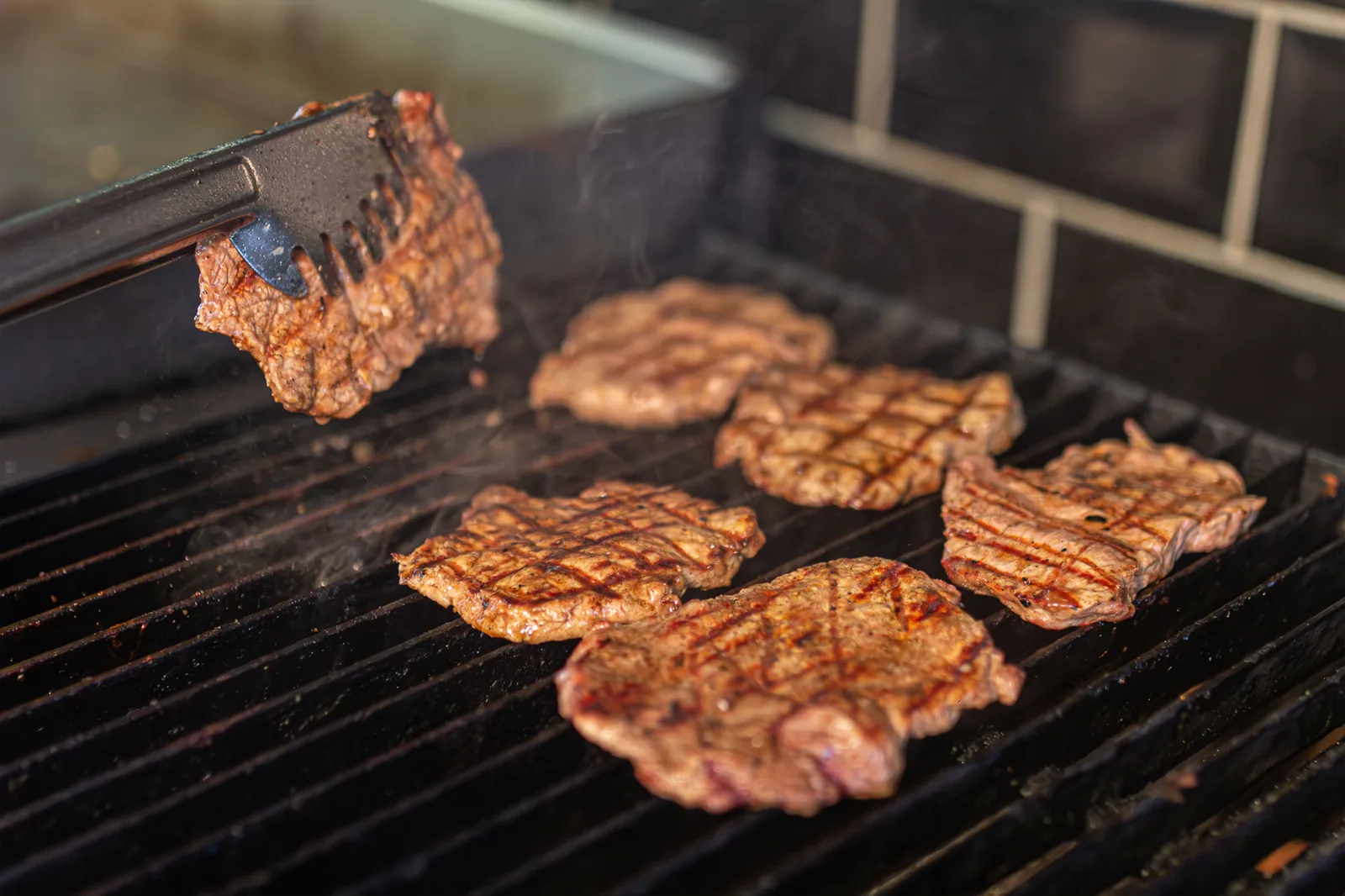 A selection of grilled meats on a taqueria griddle