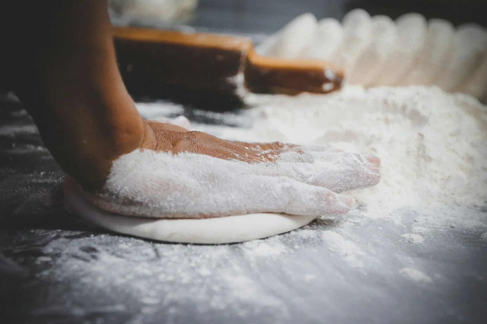 Masa being shaped by hand into a rimmed cake