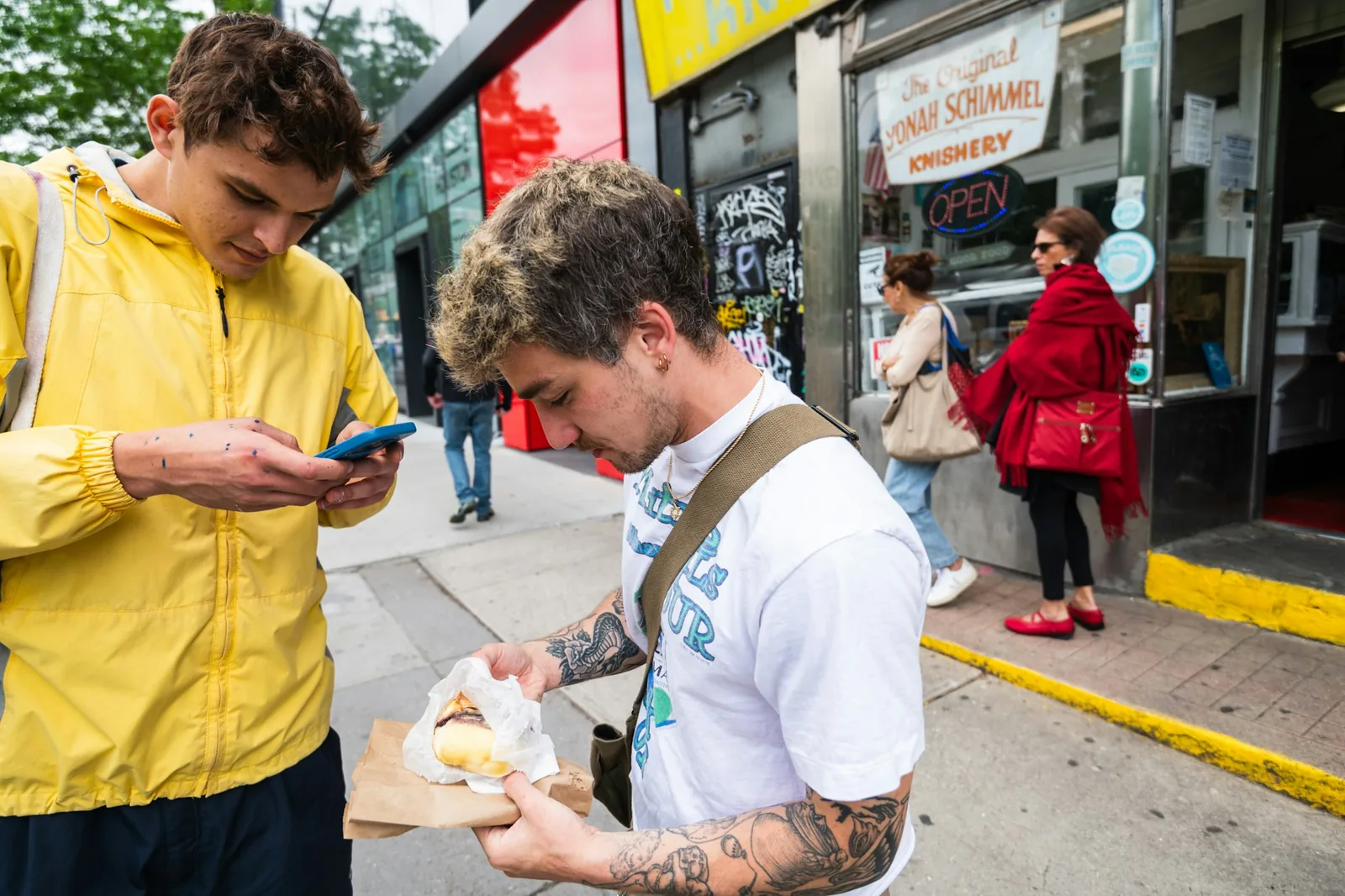 People eating tacos standing up at an outdoor food stall