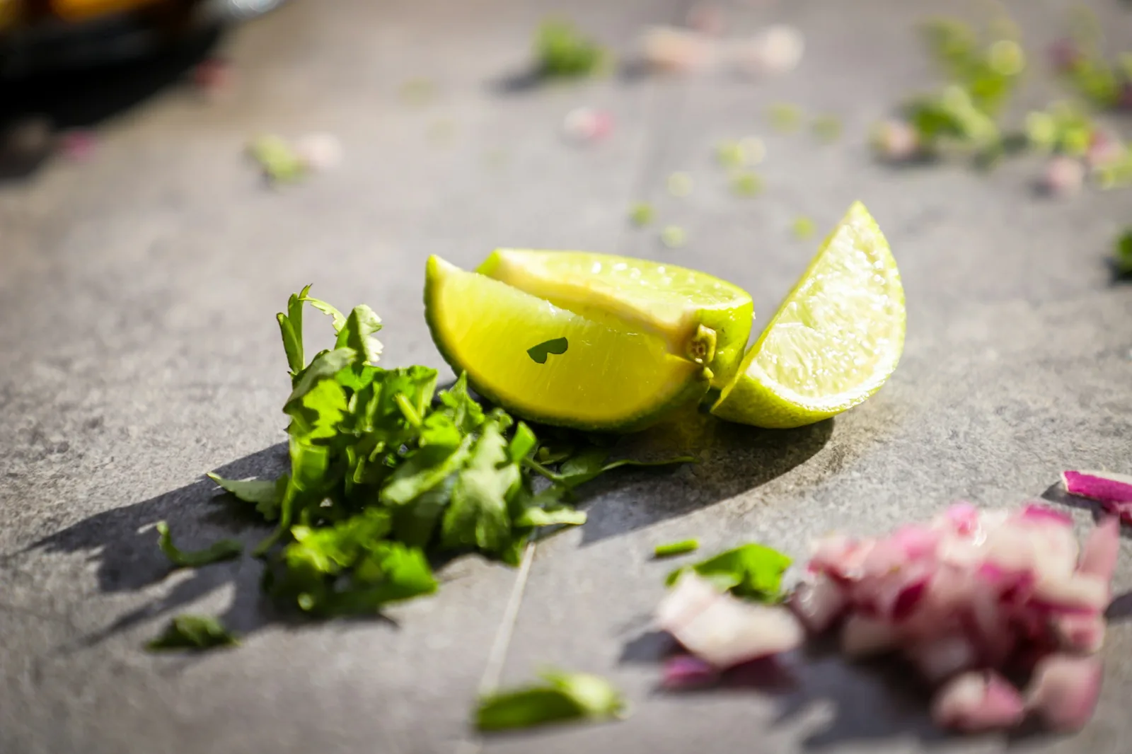 Bowls of lime wedges, chopped onion and cilantro set out as garnishes