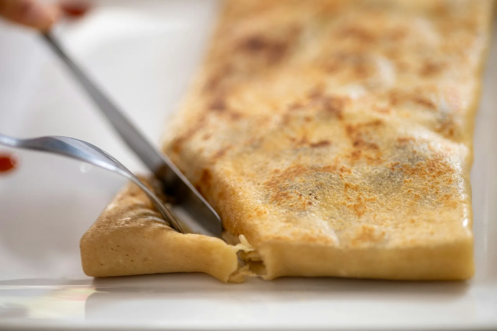 Melted cheese stretching from a griddled tortilla