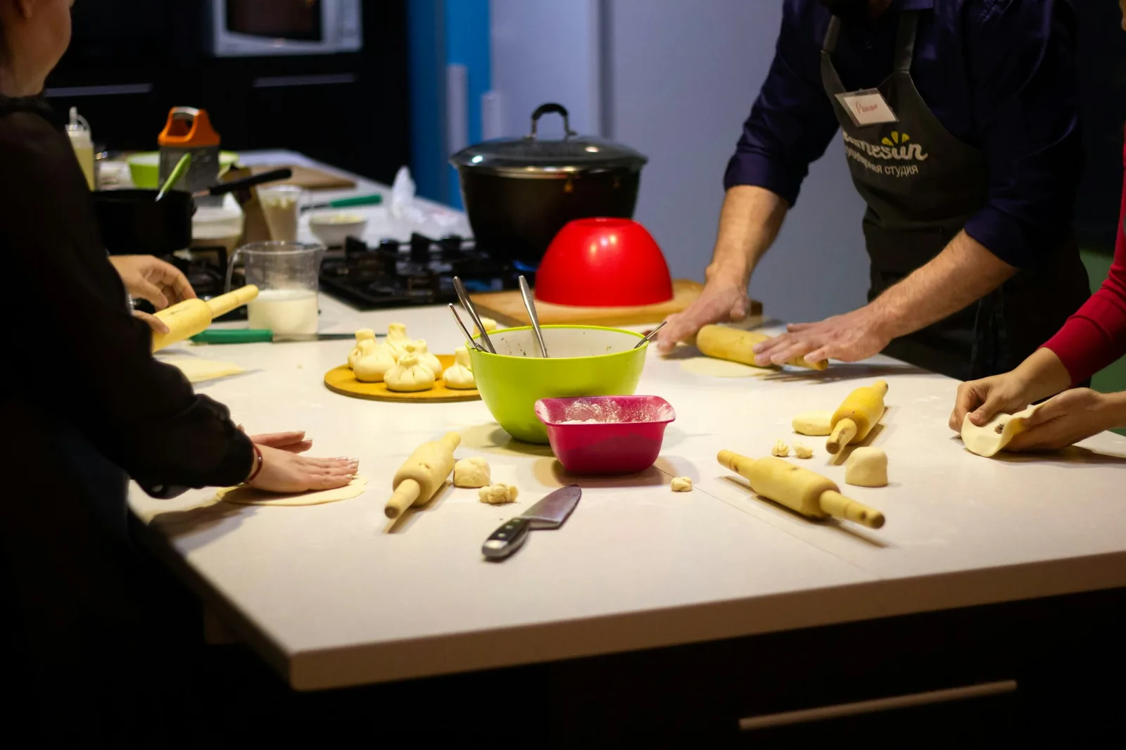 Several people making food together at one table
