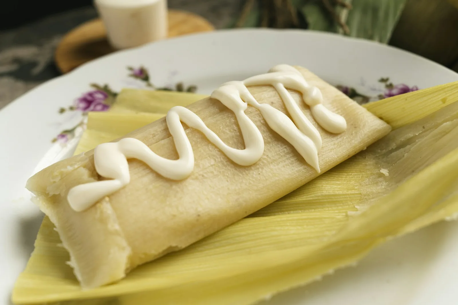 A tamal opened to show the masa and filling inside