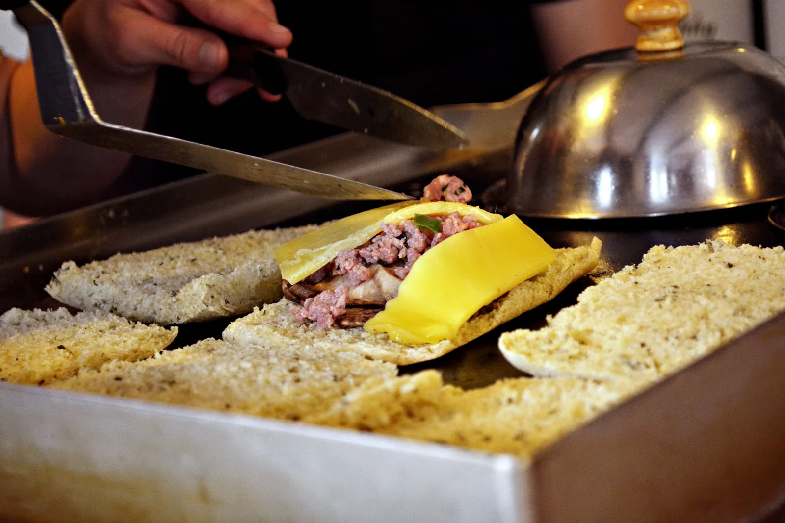 A split roll toasting face-down on a griddle