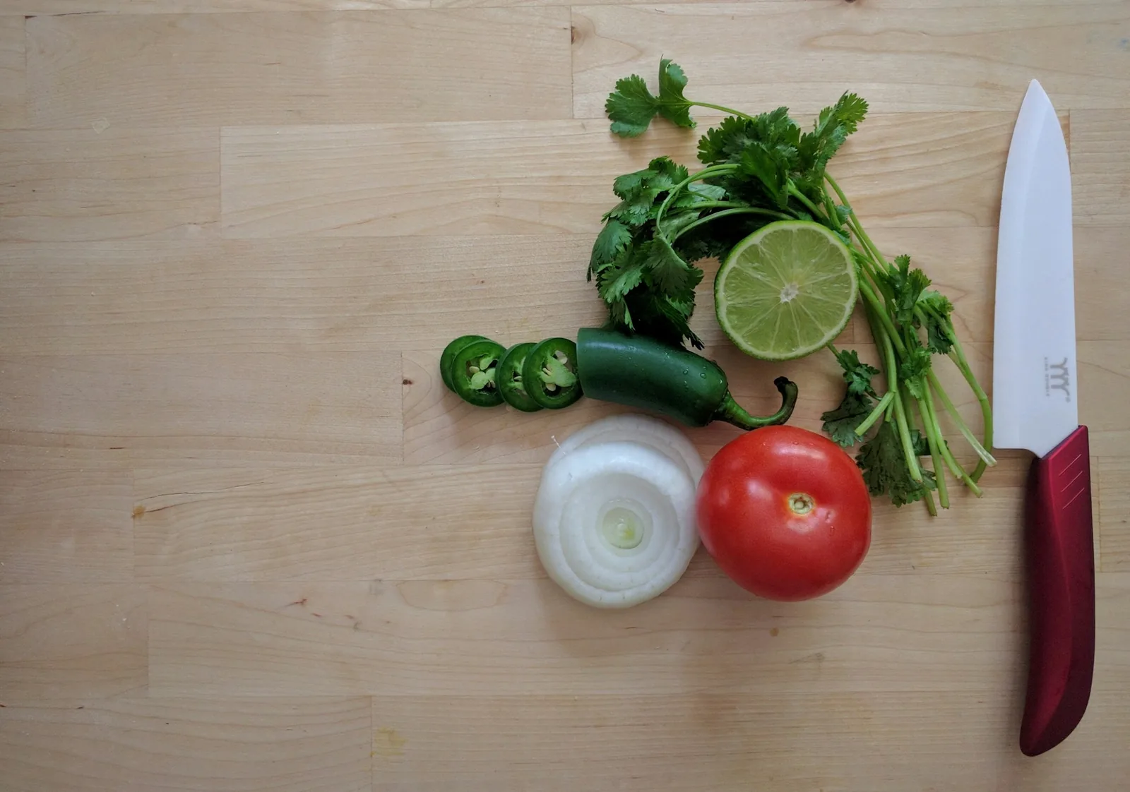 Small bowls of diced onion, chopped cilantro, lime and radish