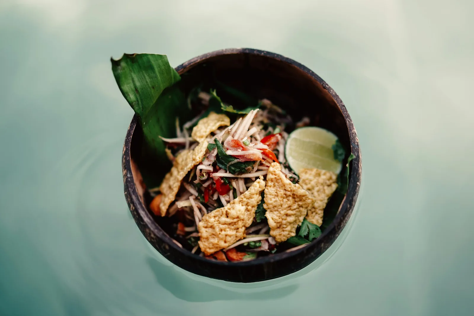 A clear soup with lime and crisp tortilla strips